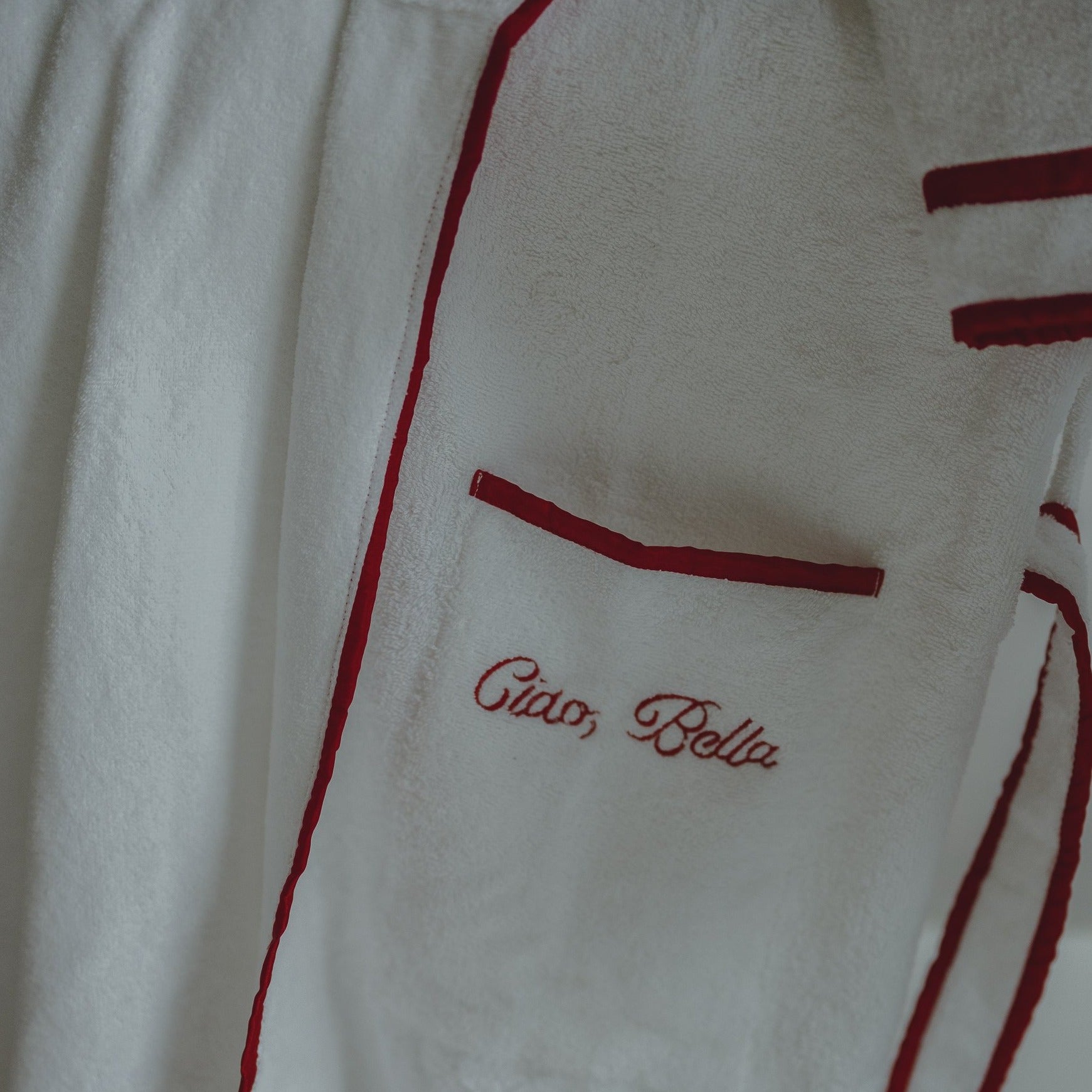A closeup of the 'Ciao Bella' embroidery on The Happily Eva After Collection Roberta Bathrobe